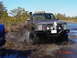1995 Dodge 1500 - This modified pickup truck navigates a muddy terrain, its off-road capabilities with a snorkel and bull bar. The license plate is RYL-75J.