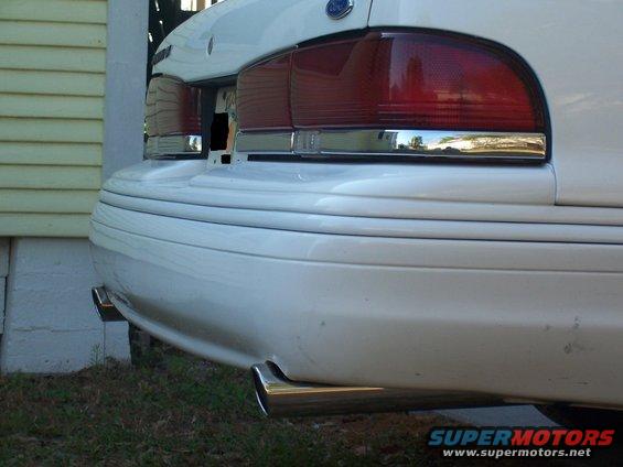 1997 Ford Crown Victoria rear bumper with dual exhaust tips and chrome trim around taillights