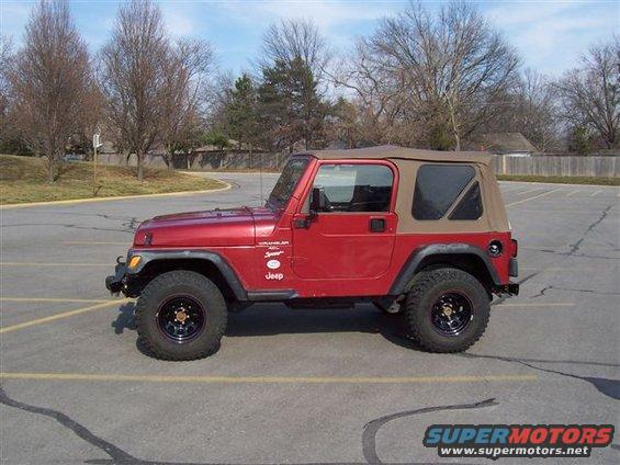 Red 1998 Jeep TJ Wrangler side view with tan soft top