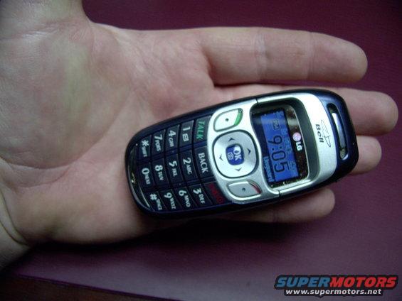 LG flip phone with '9:05' displayed on screen, held in a hand