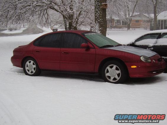 1997 Ford Taurus sedan parked in snow, another car partially visible behind it