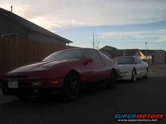 Red and white Ford Probe cars parked side-by-side on a street