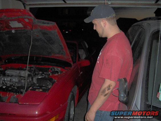guy looking at red coupe with hood open, another car next to it