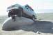 1990 Chevrolet Suburban - Man poses on a rock as his 1990 Chevrolet Suburban is positioned on top of it.