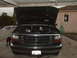 1994 Ford F-150 - Front view of a black 1994 Ford F-150's engine bay, with the hood raised and cans of soda visible.