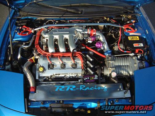 Engine bay with a supercharger, custom intake, and red spark plug wires. RR-Racing logo visible