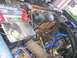 1986 Ford Bronco - Close-up view of an engine bay, an Interstate battery and various hoses and engine parts.