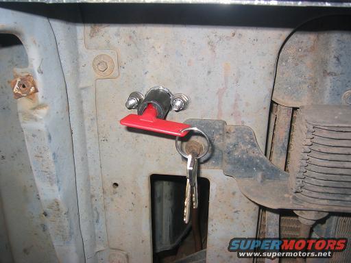 Close-up of a vehicle's ignition switch with keys in it. Some rust is visible on the surrounding metal