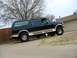 1989 Ford C-350 (Centurion Conversions) - This dark green SUV with tan trim features a visible "www.huxputz.com" decal on the rear window and appears to be a 1992 Ford F-Series mode…