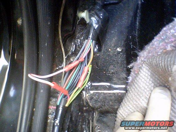 Wiring harness with red crimp connectors, inside a dark vehicle interior
