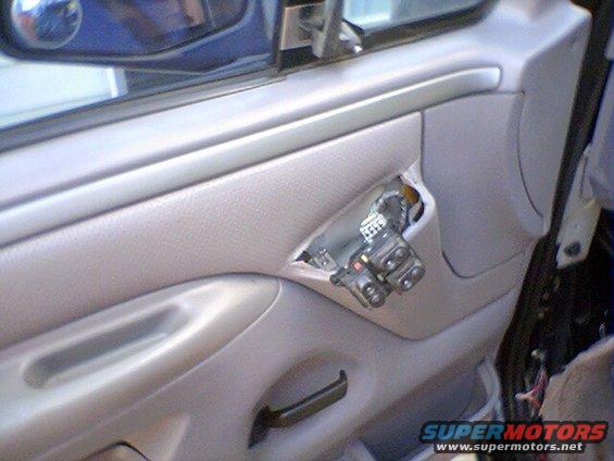 Interior door panel with exposed wiring and window controls