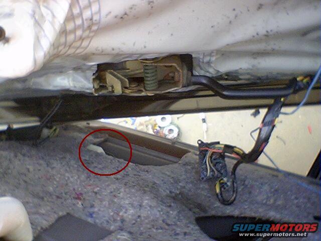 Car door interior showing latch mechanism and wiring harness during repair