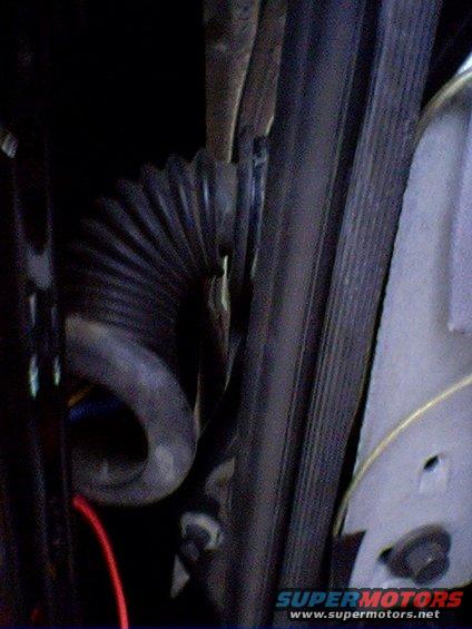 Corrugated rubber hose and ribbed belt near engine components