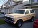 1979 Ford Bronco - This tan Ford Bronco from the late 1970s is parked in front of a suburban home.
