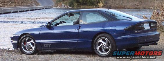 Blue 1994 Ford Probe GT coupe parked by a river, side view