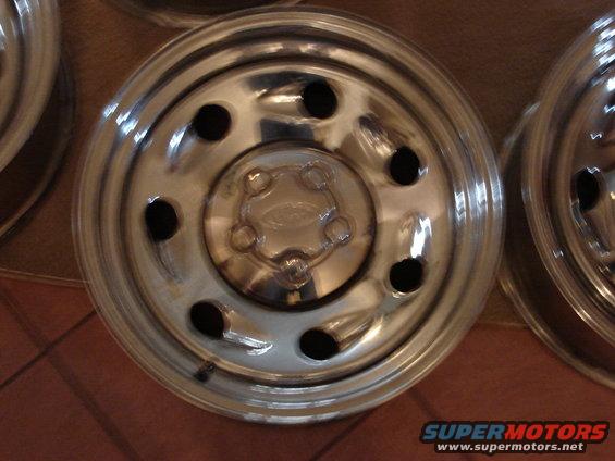 Ford wheel hubcap with five lug nut holes and a central Ford logo