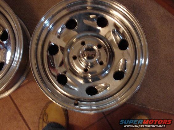 Close-up of two shiny chrome wheels with a "American Racing" center cap