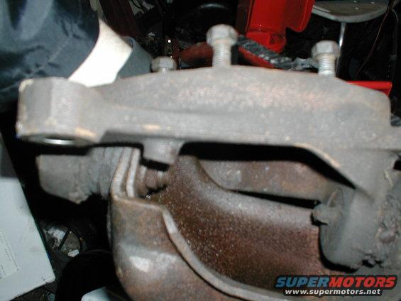 Close-up of a vehicle's brake caliper and rotor assembly, possibly undergoing maintenance