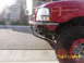 2000 Ford Ranger - Front corner view of a red 2000 Ford Ranger with a custom bumper and off-road tire.
