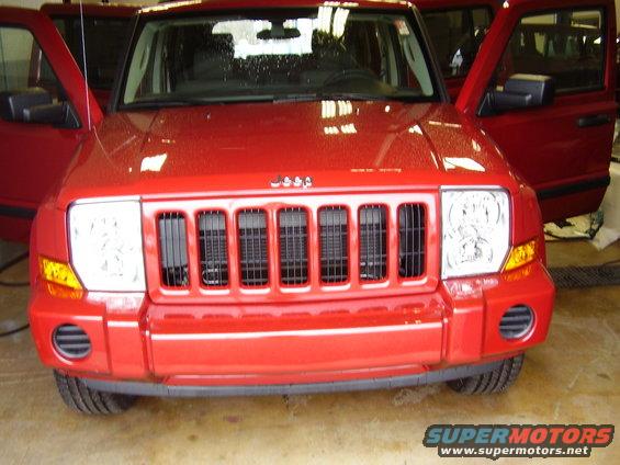 Red Jeep Commander with doors open, front view