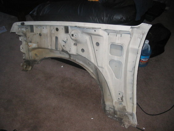 White fender well interior, showing structural supports and wheel arch