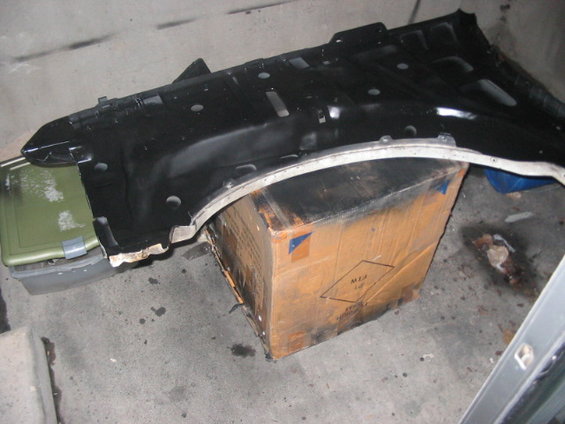 black plastic fender liner resting on a cardboard box