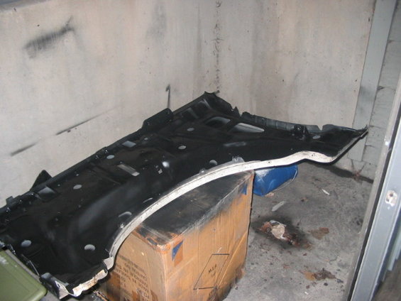 Black car undercarriage part resting on a cardboard box