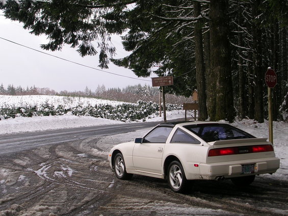 1989 Nissan 300ZX parked on a snowy road with trees and a stop sign