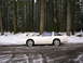 1989 Nissan 300ZX - A white 1989 Nissan 300ZX with a t-top sits on a snow-covered road, surrounded by tall trees in a winter forest.