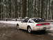 1989 Nissan 300ZX - A white 1989 Nissan 300ZX sits parked on a road covered in snow and slush, surrounded by a forest.