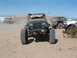 1994 Jeep YJ - A modified green Jeep Wrangler is parked in a dusty outdoor area with other vehicles present.