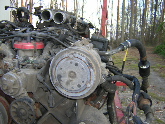 Engine assembly with air conditioning compressor and throttle body