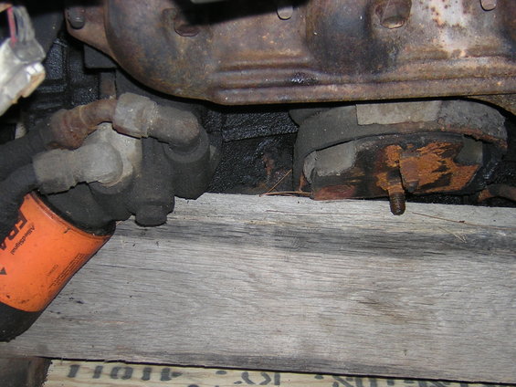Orange oil filter and engine mount on wooden planks