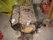 1979 Ford F-150 - A V8 engine with blue valve covers and a carburetor is shown in a workshop setting.