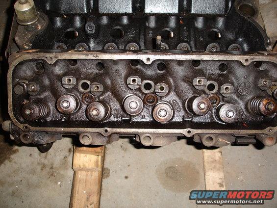 Engine cylinder head with visible valves and springs. Text 'FORD' visible