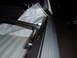 2003 Ford F-150 - Close-up view of the strut clamp hardware for a tonneau cover installed on a truck bed rail.