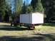 1994 Ford F-150 - A truck is seen from the rear, towing a large, boxy trailer with an 'OVERSIZE LOAD' banner.