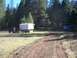 1994 Ford F-150 - A truck tows a trailer with a large white box through a wooded area.