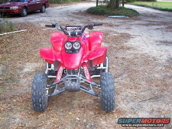 Red 2002 Honda 400 EX ATV with Renthal handlebars, parked outdoors