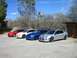1996 Ford Probe - A line of Dodge Neon SRT-4s are parked in a gravel lot with trees and a wooden structure in the background.