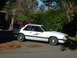 1987 Ford Mustang - White 1987 Ford Mustang with police-style markings is parked outside, with a fire truck in the background.