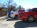 1996 Ford Probe - A line of sedans, including a red one with a prominent spoiler, are parked outdoors.