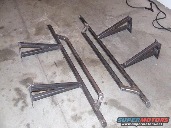 Two custom steel rock sliders on a concrete floor