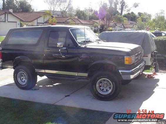 Black 1987 Ford Bronco parked on a driveway, side view
