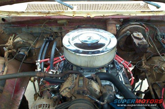 Engine bay with chrome air cleaner, red spark plug wires, and a V8 engine