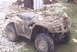 2005 Honda RANCHER - This all-terrain vehicle is heavily covered in mud, obscuring any identifying details or year.