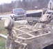 2005 Honda RANCHER - A heavily soiled ATV is in the foreground, with a pickup truck parked behind it.