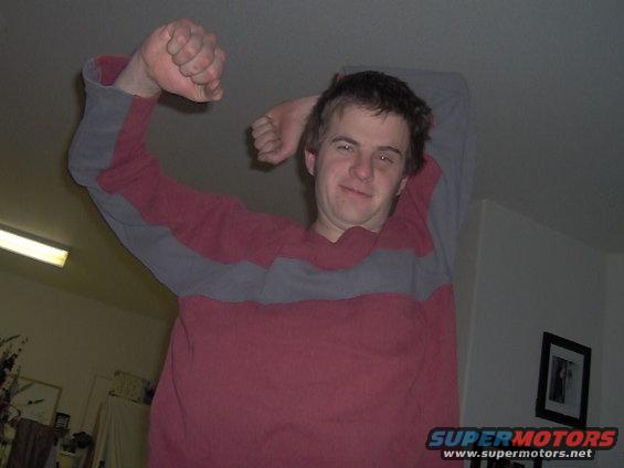 Man in a red and gray striped shirt flexing his bicep