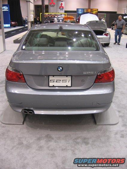 Silver BMW 525i rear view, dual exhaust pipes, on display pads