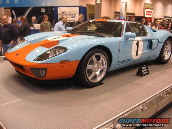 Light blue and orange Ford GT with number 1 on door, on display